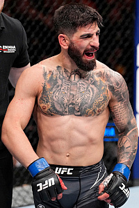 Ilia Topuria in the octagon, bloodied face after winning a match